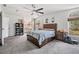 Spacious main bedroom with a ceiling fan, large bed, and natural light from windows at 7011 Tall Pine Rd, Polk City, FL 33868