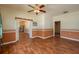 Spacious living room with hardwood floors, decorative molding, and ceiling fan with views to kitchen at 101 S Cleveland Ave, Fort Meade, FL 33841