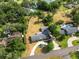 Aerial view of a property with a pool, lush landscaping, a circular driveway, and mature trees at 1205 Rolling Woods Ln, Lakeland, FL 33813