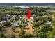 Extensive aerial image presenting a home amid trees with a distant lake view at 1205 Rolling Woods Ln, Lakeland, FL 33813