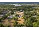 Expansive aerial shot showcasing a home nestled amongst lush greenery and a serene lake at 1205 Rolling Woods Ln, Lakeland, FL 33813