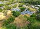 Expansive aerial view of a single-Gathering home with a large yard, pool, and mature trees at 1205 Rolling Woods Ln, Lakeland, FL 33813