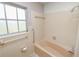 Tiled bathroom with a bathtub, shower, and window at 1205 Rolling Woods Ln, Lakeland, FL 33813