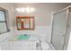 Bathroom with a mint green countertop, medicine cabinet, shower and white tiled walls at 1205 Rolling Woods Ln, Lakeland, FL 33813