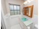 Bright bathroom with window, mint green countertop, and white tile at 1205 Rolling Woods Ln, Lakeland, FL 33813