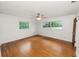 Bright bedroom features hardwood floors, dual windows, and a ceiling fan at 1205 Rolling Woods Ln, Lakeland, FL 33813