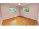 Cozy bedroom with hardwood floors, two windows, and neutral wall color at 1205 Rolling Woods Ln, Lakeland, FL 33813