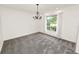 Dining room featuring neutral carpet, white walls, a chandelier, and a large window with natural light at 1205 Rolling Woods Ln, Lakeland, FL 33813