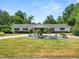 Charming single-story home featuring a well-manicured lawn and mature trees creating a serene and private setting at 1205 Rolling Woods Ln, Lakeland, FL 33813