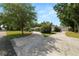 Well-maintained single-story home with a circular driveway, mature trees, and lush landscaping at 1205 Rolling Woods Ln, Lakeland, FL 33813