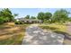 Inviting single-story home with lush landscaping, a circular driveway, and a well-maintained lawn at 1205 Rolling Woods Ln, Lakeland, FL 33813