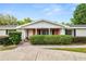 Charming home with well-manicured landscaping, a brick facade, and white columns at 1205 Rolling Woods Ln, Lakeland, FL 33813