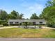 Charming one-story home with manicured lawn, circular driveway, and lush landscaping at 1205 Rolling Woods Ln, Lakeland, FL 33813
