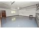 A spacious garage with a grey and white epoxy floor, overhead lighting, and automatic door at 1205 Rolling Woods Ln, Lakeland, FL 33813