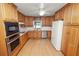 Functional kitchen with abundant wood cabinets, stainless steel appliances, and laminate flooring, offering ample storage space at 1205 Rolling Woods Ln, Lakeland, FL 33813