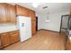 Kitchen featuring wood cabinets, a white refrigerator, and laminate flooring, connecting to a dining area with ample natural light at 1205 Rolling Woods Ln, Lakeland, FL 33813