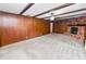 Spacious living room features a cozy brick fireplace and wood-paneled walls with overhead beams at 1205 Rolling Woods Ln, Lakeland, FL 33813
