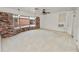 Bright living room features large bay window, exposed brick, and neutral carpet at 1205 Rolling Woods Ln, Lakeland, FL 33813