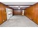This spacious living room features wood-paneled walls and sliding glass doors to an enclosed patio at 1205 Rolling Woods Ln, Lakeland, FL 33813