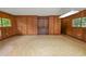 Wood paneled living room with linoleum flooring and built-in shelves at 1205 Rolling Woods Ln, Lakeland, FL 33813