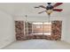 Bright living room features large bay window, exposed brick, and ceiling fan at 1205 Rolling Woods Ln, Lakeland, FL 33813