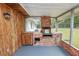 Covered patio with wood paneling and brick oven and a pass-through to the brick oven at 1205 Rolling Woods Ln, Lakeland, FL 33813