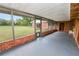 Enclosed patio with brick accents and a view of the large backyard and outdoor building at 1205 Rolling Woods Ln, Lakeland, FL 33813