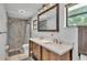 Bathroom with double sinks, granite counters, and decorative tile shower at 1433 Ellison Ln, Lakeland, FL 33801