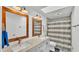 Bathroom featuring double sinks, framed mirrors, and a shower with a striped shower curtain at 1433 Ellison Ln, Lakeland, FL 33801