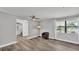 Cozy living room featuring wood-look floors, a ceiling fan, and a large window for natural light at 1433 Ellison Ln, Lakeland, FL 33801