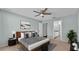 A cozy bedroom setup with a gray color scheme, ceiling fan and en suite bathroom at 1520 Caroline Ct, Bartow, FL 33830