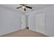 Carpeted bedroom with a ceiling fan and double closets for ample storage at 1520 Caroline Ct, Bartow, FL 33830