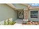 Charming home entrance features a stone column accent, white front door, and well-maintained landscaping at 1520 Caroline Ct, Bartow, FL 33830