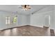 Bright living room with wood-look flooring, ceiling fan, and access to the screened lanai at 1520 Caroline Ct, Bartow, FL 33830