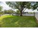 Large, well-maintained backyard featuring lush grass, mature trees, and white fencing for privacy at 1536 Del Crest Pl, Lakeland, FL 33803
