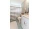 This bathroom is finished with white cabinets, a shower-tub, and a striped shower curtain at 1536 Del Crest Pl, Lakeland, FL 33803