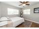 This simple bedroom is brightly lit with wood-look floors, a ceiling fan, and white bedding at 1536 Del Crest Pl, Lakeland, FL 33803