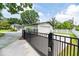 Gated driveway leading to a white home with lush landscaping and mature trees at 1536 Del Crest Pl, Lakeland, FL 33803