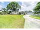 Well-maintained home featuring a lush front yard with mature trees and a long driveway at 1536 Del Crest Pl, Lakeland, FL 33803