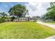 Charming home featuring a well-manicured front yard, mature trees, and a long driveway at 1536 Del Crest Pl, Lakeland, FL 33803