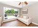 Sun room with a white couch, a large window looking out to the fenced in back yard at 1536 Del Crest Pl, Lakeland, FL 33803