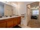 Bright bathroom with dual sinks, granite counters, and an adjoining bedroom at 1620 Linz Ct, Winter Haven, FL 33884