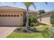 Home exterior featuring a manicured lawn, tropical landscaping, and a brick-paved walkway at 1620 Linz Ct, Winter Haven, FL 33884