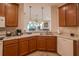 Well-lit kitchen features wood cabinets, stainless steel sink and eat-in counter at 1620 Linz Ct, Winter Haven, FL 33884