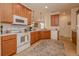 Kitchen features granite countertops, white appliances, and wood cabinets in a well lit area at 1620 Linz Ct, Winter Haven, FL 33884