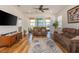 Cozy living room with hardwood floors, plush sofas, and sliding glass doors to the lanai at 1620 Linz Ct, Winter Haven, FL 33884