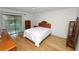 A bright bedroom with hardwood floors, a queen bed, and a sliding glass door leading to the outdoors at 2025 Sylvester Rd # E2, Lakeland, FL 33803