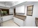 Bright kitchen featuring white cabinets and a tile countertop, with natural light from a window at 2025 Sylvester Rd # E2, Lakeland, FL 33803