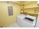 Laundry room features modern washer and dryer units, along with shelving, offering convenience and functionality at 2025 Sylvester Rd # E2, Lakeland, FL 33803
