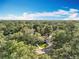 Aerial view of home surrounded by lush greenery, blue skies and mature trees at 203 N Sweetwater Blvd, Longwood, FL 32779